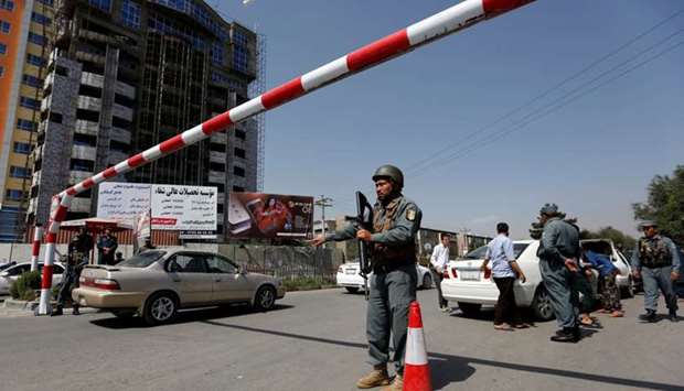 An Afghan police officer inspects vehicles at a checkpoint in Kabul, Afghanistan