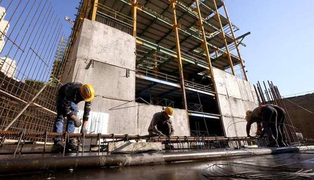 Labourers work at the construction site of a building