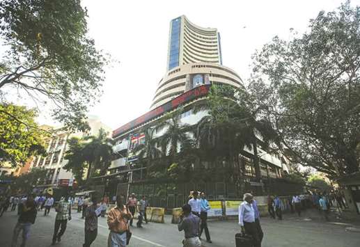 People walk by the Bombay Stock Exchange building in Mumbai. The Sensex closed down 259.48 points to 32,014.19 yesterday.