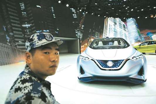 A security guard stands next to a Nissan IDS concept car displayed during the Auto China 2016 auto show in Beijing. Nissan said it would take over NECu2019s 49% stake in the battery venture and then sell the business to GSR. NEC will book about u00a510bn ($90mn) in non-operating income from the sale, the company said in a  press release.