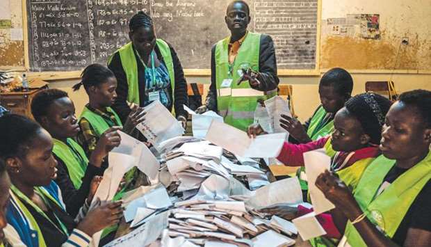 Voting officials count ballots last night at the Victoria primary school polling station in Kisumu.