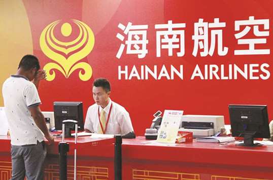 A customer stands in front of a counter of Hainan Airlines, a part of Chinese conglomerate HNA Group, at an airport in Haikou, China. HNA yesterday closed its acquisition of an 82.5% stake in Germanyu2019s Hahn airport, which it bought for u20ac15.1mn (17.8mn) from the federal state of Rhineland-Palatinate, the airportu2019s local government owner.