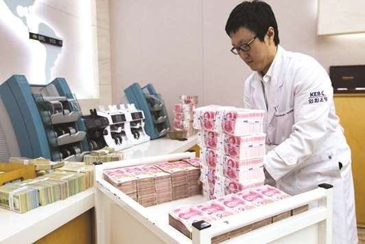 An employee arranges yuan banknotes at the Korea Exchange Bank headquarters in Seoul. The ever-louder chatter about whether China is close to widening the yuanu2019s  trading band is being met with scepticism by traders and analysts.