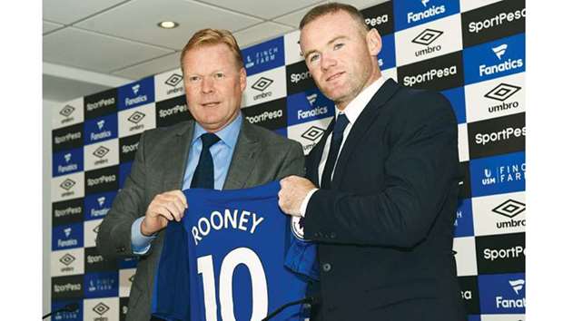 This file photo shows Evertonu2019s new signing, Wayne Rooney (R) posing for a photograph with manager Ronald Koeman.