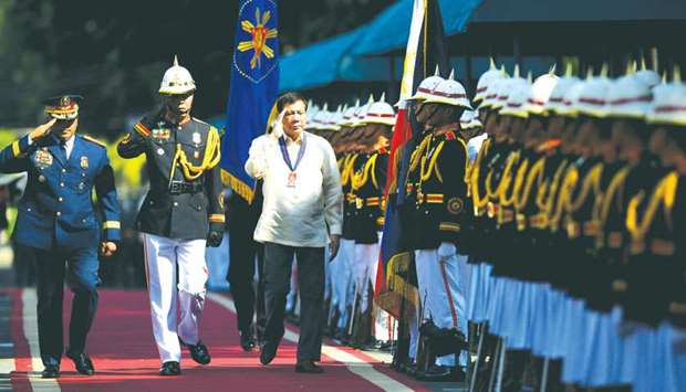 Philippine President Rodrigo Duterte with Philippine National Police (PNP) chief Ronald dela Rosa salute honour guards during the 116th anniversary of the PNP at its headquarters in Manila.