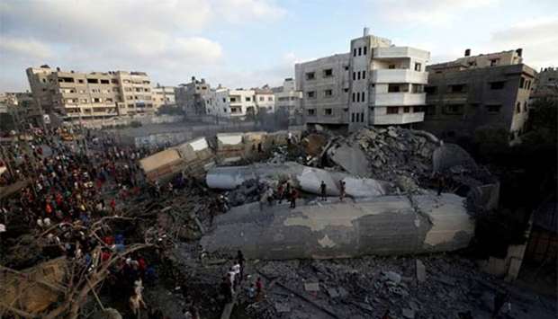 Palestinians gather around a building after it was bombed by an Israeli aircraft, in Gaza City on Thursday.