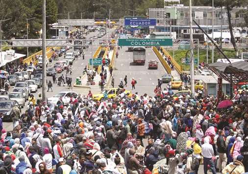 Venezuelan migrants stand in line to register their exit from Colombia before entering into Ecuador, at the Rumichaca International Bridge, Colombia.