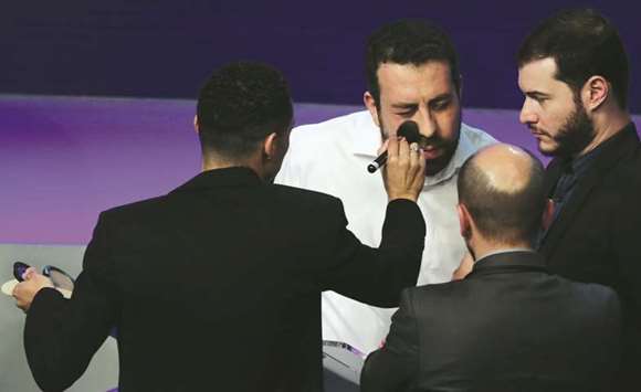 Presidential candidate Guilherme Boulos of the Socialism and Freedom Party (PSOL) gets a touchup from a network makeup artist during the first television debate at the Bandeirantes TV studio in Sao Paulo.