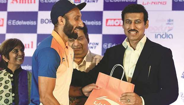 Indian sports minister Rajyavardhan Singh Rathore gives a kit to Indian hockey player Sardar Singh during the send-off ceremony to the Indian contingent for the Jakarta-Palembang 2018 Asian Games in New Delhi yesterday. (AFP)