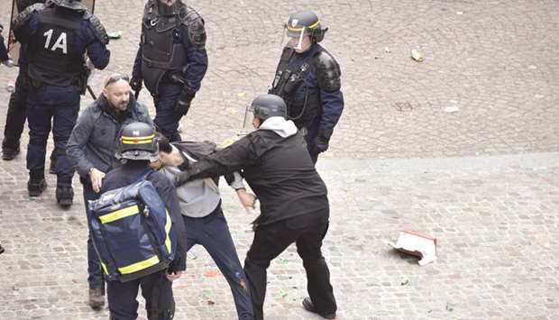 This file photo taken on May 1 shows Benalla (centre), wearing a police visor, next to Vincent Crase (centre left) as they drag away a demonstrator during a protest in Paris.