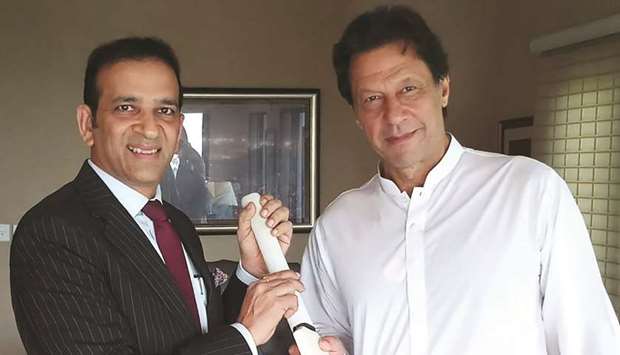 In this handout picture released by the Pakistan Tehreek-e-Insaf (PTI) yesterday, Indian high commissioner to Pakistan Ajay Bisaria presents a cricket bat to Imran Khan during a meeting in Islamabad. PTI chief Khan will be sworn in as prime minister next week, his party said yesterday.