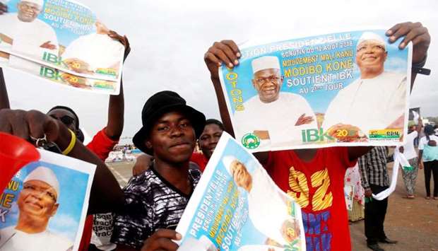 Supporters of Ibrahim Boubacar Keita, President of Mali and candidate for Rally for Mali party (RPM), carry his pictures during a rally in Bamako