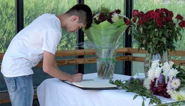 A man signs a condolence book at the US Embassy in Dushanbe in tribute to the victims of a deadly attack.