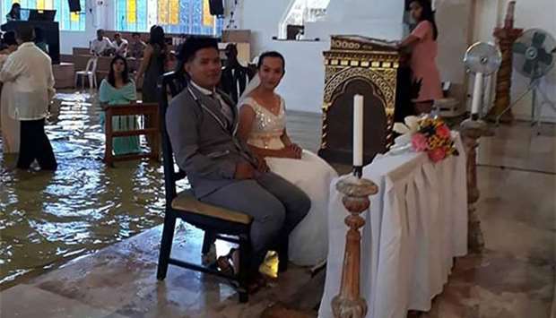 Jobel Delos Angeles and her groom are seen during their wedding amidst a flooded church in Hagonoy town, Bulacan, north of Manila, on Saturday.