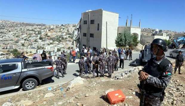 Jordanian security forces gather near a damaged building in Salt, northwest of Amman, on Sunday.