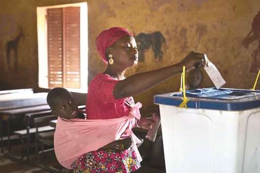 A woman with her child casts her vote at a polling station in Bamako yesterday.