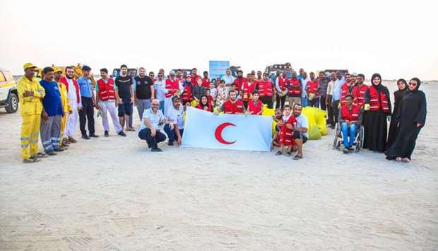 QRCS volunteers pose for a group photograph after cleaning the Eraida beach on the occasion of International Youth Day.