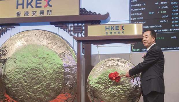 Tong Jilu, chairman of China Tower Corp, poses for photographs in front of a gong during the companyu2019s listing ceremony at the Hong Kong Stock Exchange on August 8. China Tower averted a repeat of smartphone maker Xiaomiu2019s disappointing coming-out party last month and eased concerns about future IPO prospects.