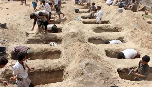 Yemenis dig graves for children, who where killed when their bus was hit during a Saudi-led coalition air strike, that targeted the Dahyan market the previous day in the Huthi rebels' stronghold province of Saada on August 10, 2018.