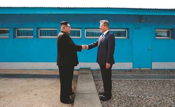 In a file picture, North Koreau2019s leader Kim Jong-un shakes hands with South Koreau2019s President Moon Jae-in at the Military Demarcation Line that divides their countries at the truce village of Panmunjom.