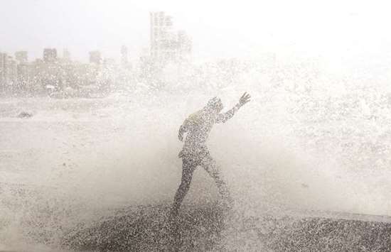 A man loses his balance as he gets drenched by a large wave during high tide at a seafront in Mumbai yesterday.