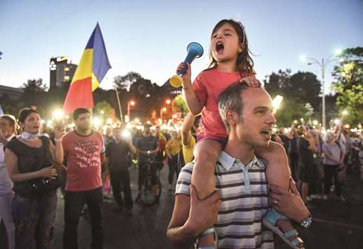 This picture taken on Sunday shows people gathering for an anti-government protest in front of the government headquarters in Bucharest.