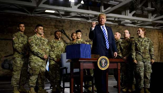 US President Donald Trump stands up after signing the u201cJohn S. McCain National Defense Authorization Act for Fiscal Year 2019u201d at Fort Drum, New York