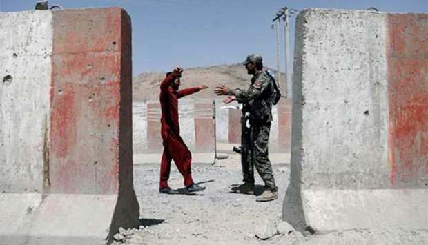 An Afghan National Army soldier inspects a passenger at a checkpoint on the Ghazni-Kabul highway on Tuesday.