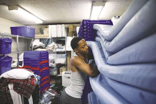 David Williams, 22, sorts through the sleeping mats he cleaned the prior night as part of his chores at The Crib, a place for homeless kids to seek shelter, located in the basement of Lakeview Lutheran Church in Chicago on July 31.