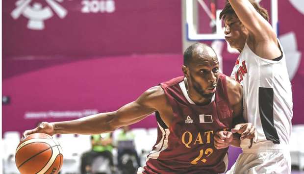 Qataru2019s Khalid Abdi (left) manoeuvres past Hong Kongu2019s Cheng Kam Hing in their menu2019s basketball preliminary Group C game at the 2018 Asian Games in Jakarta yesterday. Abdi was the leading scorer for Qatar with 19 points. (AFP)