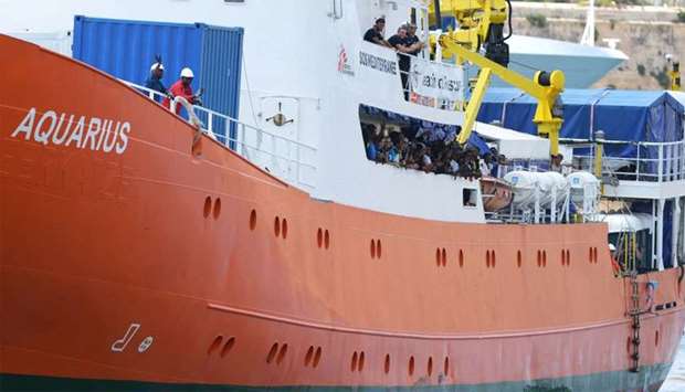 Migrants stand aboard the Aquarius rescue ship as it arrive at Bolier Wharf in Senglea, Malta