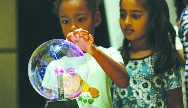 A Summer of Learning participant learns about static electricity using a plasma ball