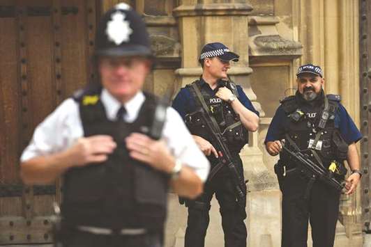 Armed police stand outside the Houses of Parliament in central London yesterday.