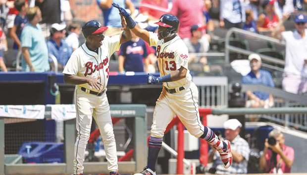 Atlanta Braves left fielder Ronald Acuna Jr. (right) celebrates with third base coach Ron Washington after hitting a three-run home run against the Miami Marlins in the seventh inning at SunTrust Park. PICTURE: USA TODAY Sports