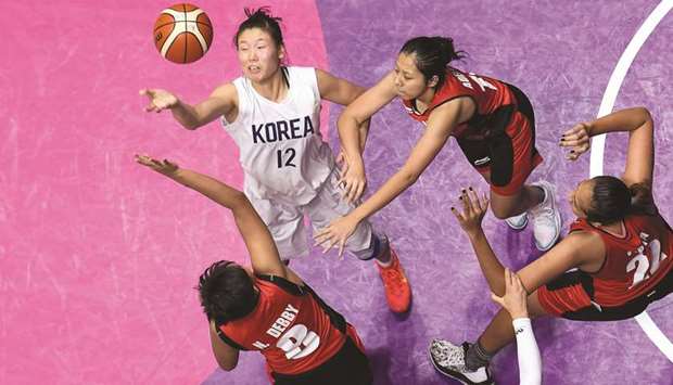 Unified Koreau2019s Ro Suk-yong (top left) and Indonesiau2019s Christaline Nathan Debby (bottom left) vie for the ball during the womenu2019s basketball preliminary game between Unified Korea and Indonesia during the 2018 Asian Games in Jakarta yesterday. (AFP)
