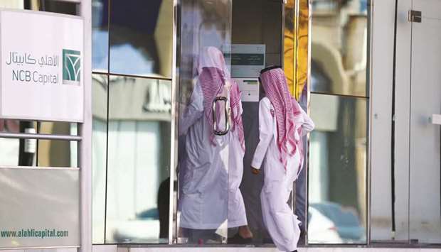 Men arrive at the NCB Capital office in Riyadh (file). There is growing  pressure on the PIF to spend money at home, where a slumping economy has driven unemployment among Saudi citizens to record highs.