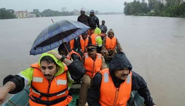 Indian fire and rescue personnel evacuate local residents following flooding at Aluva, Kerala, on Thursday.