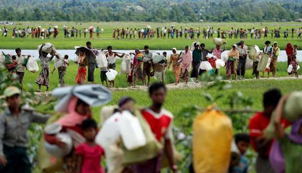 Rohingya refugees, who crossed the border from Myanmar two days before, walk after they received permission from the Bangladeshi army to continue on to the refugee camps, in Palang Khali, near Cox's Bazar, Bangladesh.