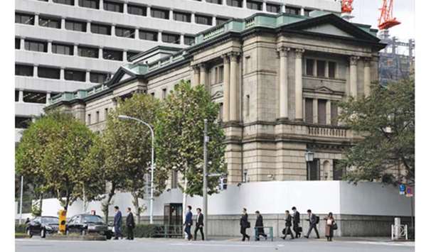 Pedestrians cross a road in front of the Bank of Japan headquarters in Tokyo. The BoJ appears to be growing more comfortable with larger declines in the countryu2019s stock prices, a sign it may have begun in the share market what analysts describe as u201cstealth taperingu201d of its massive monetary stimulus.