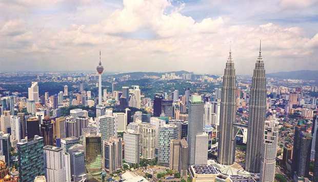Skyscrapers are seen in Kuala Lumpur. Malaysia cut its full-year growth forecast and reported much slower second-quarter expansion yesterday, as the country reviews mega projects and tackles a massive debt left by the previous government.