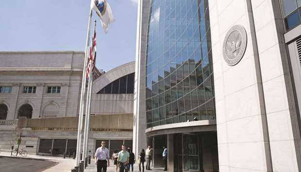 People walk outside the Securities and Exchange Commission (SEC) headquarters in Washington (file). Any move to scrap quarterly filings would have to be voted on by the SECu2019s sitting commissioners, who are political appointees.