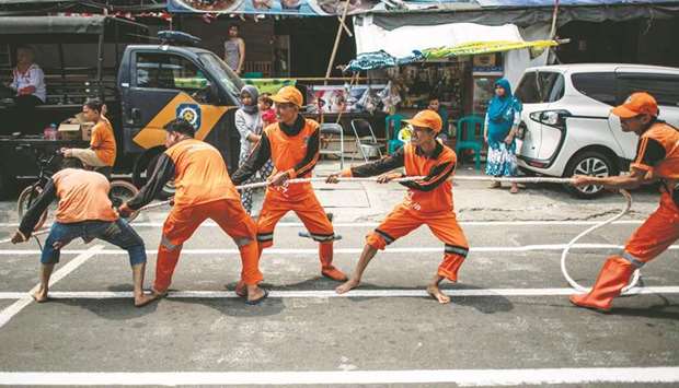 Indonesian workers play a game of tug-of-war game in Jakarta yesterday. (AFP)