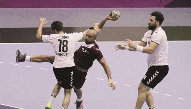    Qataru2019s Moustafa Heiba (centre) in action during the menu2019s Group A preliminary handball match against Iran yesterday. Heiba scored six goals.