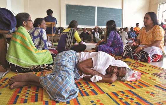 Flood victims rest inside a university classroom, which is converted into a temporary relief camp in Kochi.