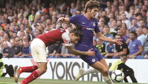 Chelseau2019s Marcos Alonso (right) vies for the ball with Arsenalu2019s Hector Bellerin during the English Premier League football match at Stamford Bridge in London yesterday. (AFP)