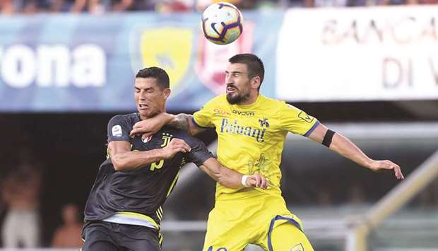 Juventusu2019 Cristiano Ronaldo (left) and Chievo Veronau2019s Nenad Tomovic go for a header during the Serie A match yesterday. (Reuters)