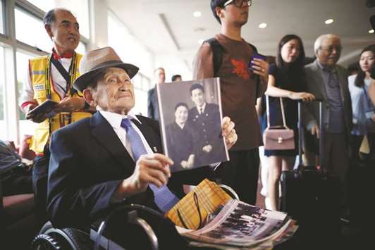 A man who has been selected as a participant for a reunion holds an old picture at a hotel used as a waiting place in Sokcho, South Korea.