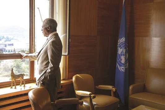 In this file photo taken on July 20, 2012, Annan looks through a window before a meeting at his office at the United Nations Offices in Geneva.