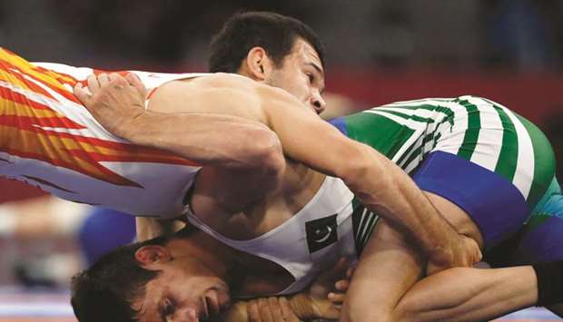 Makhmudjon Shavkatov (top) of Uzbekistan in action with Pakistanu2019s Mohamed Bilal during the menu2019s Freestyle 57kg qualification round in Jakarta yesterday. (Reuters)