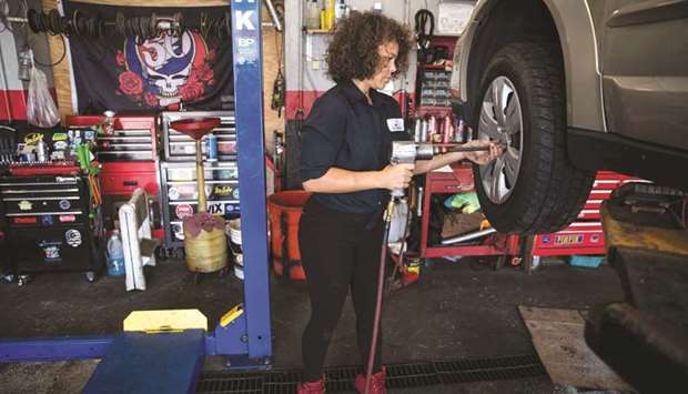 Patrice Banks, founder and owner of the Girls Auto Clinic, mounts a wheel on a car at her garage in Upper Darby, Pennsylvania.